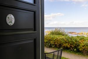 阿灵厄Allinge Badehotel的黑色的门,门扣和椅子