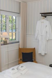 阿灵厄Allinge Badehotel的一间卧室配有一张床,墙上挂着一个长袍