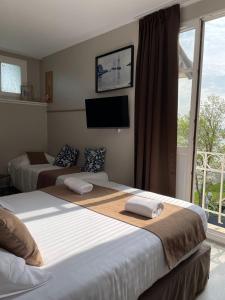 索姆河畔的圣瓦列里Logis Hôtel- Restaurant Le Relais Guillaume de Normandy的一间卧室设有两张床、一台电视和一扇窗户。