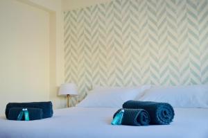 卡塞雷斯Apartamento Turístico Clavellinas IV的一间卧室配有一张带蓝色毛巾的床