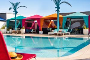 奥兰多Lake Nona Wave Hotel的一座带色彩缤纷小屋的酒店游泳池