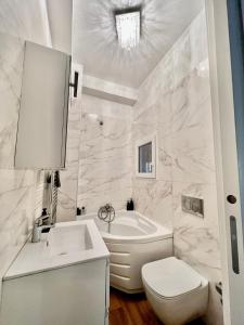 塞格拉泰white home near Linate的带浴缸、卫生间和盥洗盆的浴室