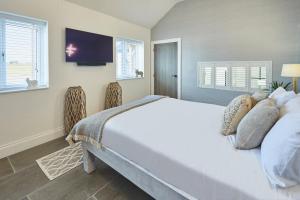 亚姆Host & Stay - The Stables的卧室配有一张白色大床和电视。