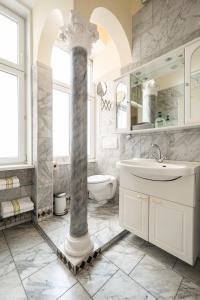 维也纳普利马维拉酒店的一间带柱子、水槽和卫生间的浴室