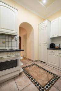 维也纳普利马维拉酒店的厨房配有白色橱柜和瓷砖地板。