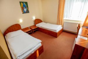 日利纳波什酒店的小房间设有两张床和窗户