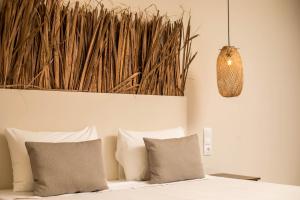 法里拉基Atma Beach Rooms & Suites的一间卧室配有一张带枕头和吊灯的床。