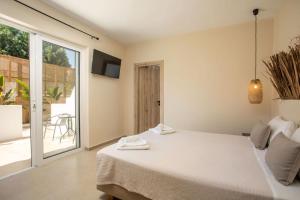 法里拉基Atma Beach Rooms & Suites的一间卧室设有一张床和一个滑动玻璃门
