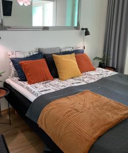 奥卢StarHomes Studio Lux 10的一张床上有色彩缤纷的枕头