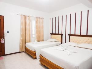 长滩岛蓝珊瑚长滩岛住宿加早餐旅馆的一间卧室设有两张床和窗户。