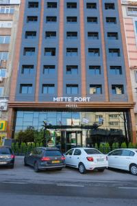 伊兹密尔Mitte Port Hotel Konak Izmir的一座大型建筑,前面有汽车停放