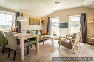 登霍伦Camping Loodsmansduin的用餐室以及带桌椅的起居室。