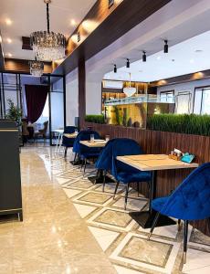 阿特劳Rush Hotel的一间在房间内配有蓝色椅子和桌子的餐厅