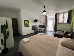 都灵Hostel Turin Metro Young的一间卧室配有一张床、一张沙发和一张桌子
