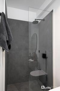 比雷埃夫斯La Mer Apartment by LobbySquare的一间带玻璃淋浴间和水槽的浴室