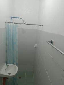 爱妮岛布卡纳海滨宾馆的白色的浴室设有水槽和淋浴。