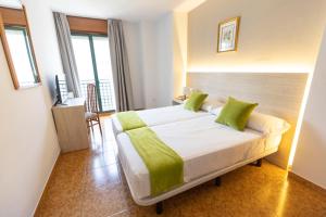 庞特维德拉马德里酒店的一间卧室配有一张带绿色枕头的大床