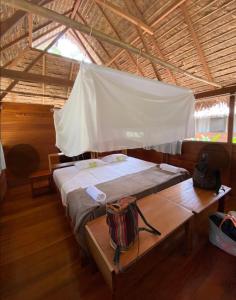 马尔多纳多港Ecolucerna Lodge Tambopata的一间卧室配有一张床,帐篷内配有一张桌子