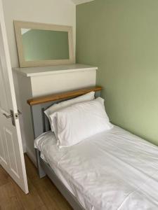 RiscaPontymister Retreat的一张带白色枕头和镜子的床