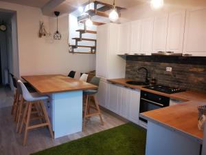 布朗Casa din vale的厨房配有白色橱柜和木制台面