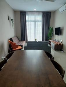 Bandar PenawarPangsapuri Desaru Utama Homestay的客厅配有桌子和沙发