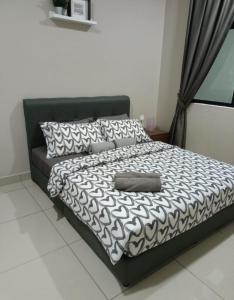 Bandar PenawarPangsapuri Desaru Utama Homestay的一张带黑白棉被和枕头的床