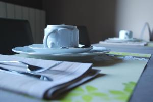 希迈Hotel De Franc Bois的桌上放有盘子的桌子和咖啡杯