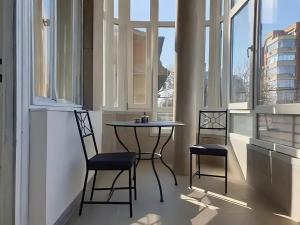 蒂米什瓦拉Belle Vue Ultracentral Apartments的窗户间配有一张桌子和两把椅子
