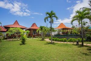 蓝梦岛Pondooks Joglo的棕榈树度假村和带庭院的度假屋