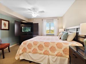 默特尔比奇Yacht Club Villas #2-405 condo的一间卧室配有一张大床和电视