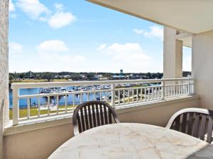 默特尔比奇Yacht Club Villas #2-405 condo的阳台配有桌椅,享有水景。