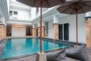 库塔Guyana Hotel的一座带遮阳伞的室内游泳池