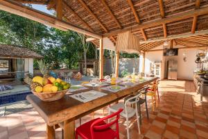 托兰克索Casa Caminho do Mar (TRANCOSO-BA)的户外用餐室,配有带一碗水果的桌子