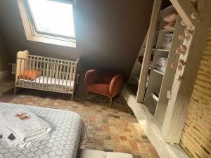 拉弗雷切Chambre Alix的一间婴儿卧室,配有婴儿床和椅子