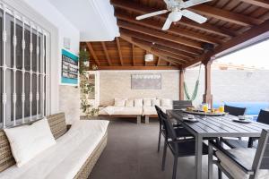 阿德耶LUXURY VILLA WITH PRIVATE POOL WITH AIRCON,Playa del Duque的天井配有桌椅和沙发。