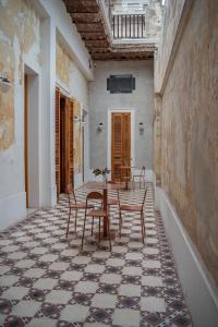 罗萨里奥Hotel Casa Allegra Art Suites的客房铺有瓷砖地板,配有桌椅。