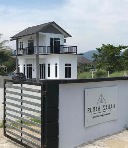 巴西富地Rumah Sawah Homestay Pasir Puteh的白色的房子,有黑白的围栏
