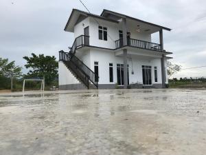 巴西富地Rumah Sawah Homestay Pasir Puteh的前面有充水停车位的房子