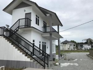 巴西富地Rumah Sawah Homestay Pasir Puteh的白色的房子,前面有楼梯