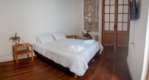 罗萨里奥Hotel Casa Allegra Art Suites的卧室设有一张白色大床和木地板