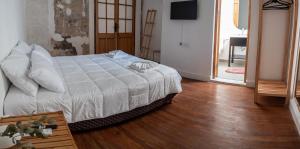 罗萨里奥Hotel Casa Allegra Art Suites的一间卧室配有一张床,铺有木地板