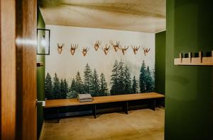 贝里斯泽尔Alpenrose Bayrischzell Hotel的木板凳,有壁画的房间
