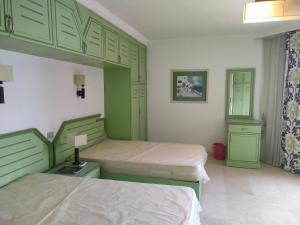 赫尔格达Marena Hurghada的一间卧室配有两张带绿柜的床
