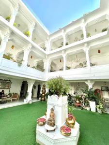 乌代浦杰加特尼瓦斯宫殿酒店的一座白色的大建筑,设有绿色的地板和天花板