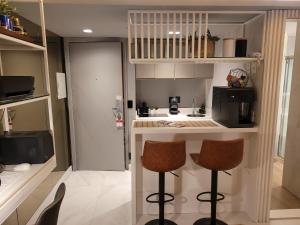 圣保罗Hotel Bourbon Ibirapuera Suite 5 estrelas Moema的一个带两个吧台凳和柜台的小厨房