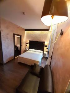 都灵大陆酒店的一间卧室配有床、灯和沙发