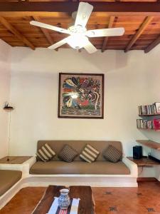特隆戈内斯Casita Monarca的带沙发和吊扇的客厅