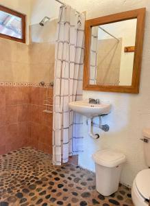 特隆戈内斯Casita Monarca的一间带水槽、卫生间和镜子的浴室