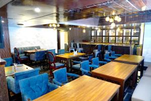 阿姆利则Keyonn Hotels & Resorts的餐厅设有木桌和蓝色椅子