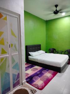 加央MyHomestay07的一间卧室设有一张床和绿色的墙壁